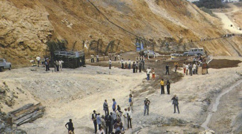Crowd of visitors at the Oklo uranium mine site in Gabon, beside an exposed rock face