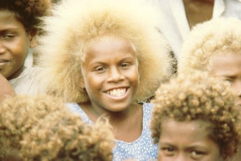 Smiling dark-skinned children with naturally blond curly hair