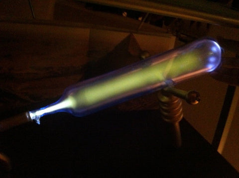 Working model of the Dendera lamp: a glass bulb glowing green and violet with electric discharge in the dark