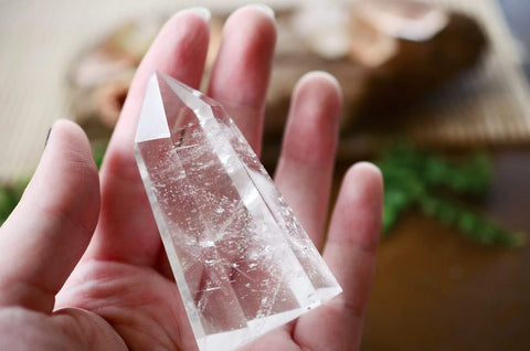 Clear quartz crystal point held in an open palm