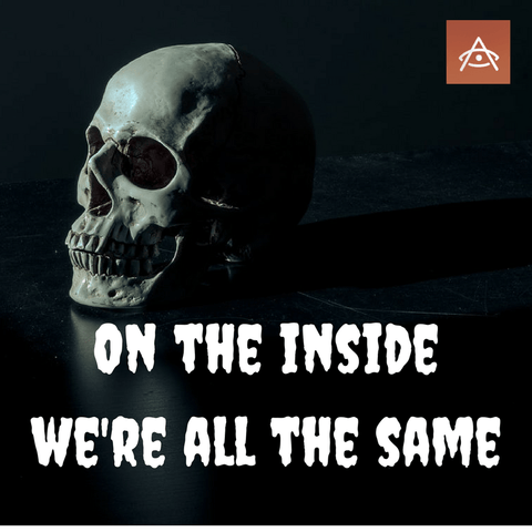 Human skull in dim light with text "On the inside we're all the same"