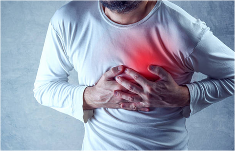 Man in a white long-sleeve shirt clutching his chest over a glowing red area near the heart