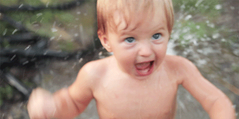 Animated GIF of a shirtless toddler shouting excitedly as water splashes around him
