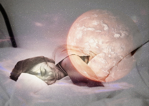 Woman asleep under a blanket with a large glowing reddish planet overlaid on the scene