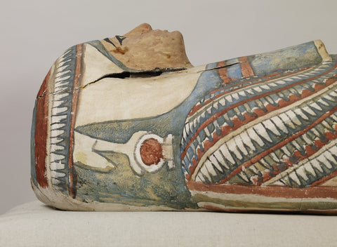 Painted Egyptian mummy mask with red, blue and white collar patterns, seen in profile