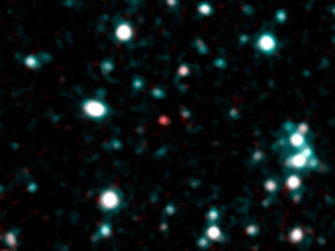 Infrared telescope image of a star field with a faint red dot at center marking a cold brown dwarf