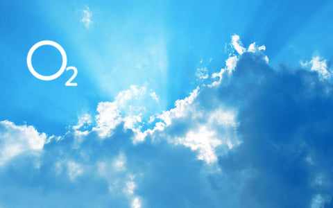 Blue sky with sunlit clouds and the chemical symbol O2 for oxygen