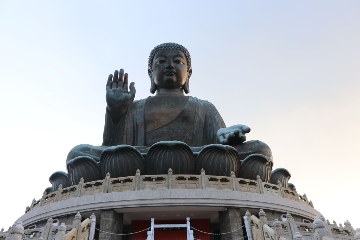 The bronze Tian Tan Buddha on Lantau Island, Hong Kong, seen from below with his right hand raised, palm facing out