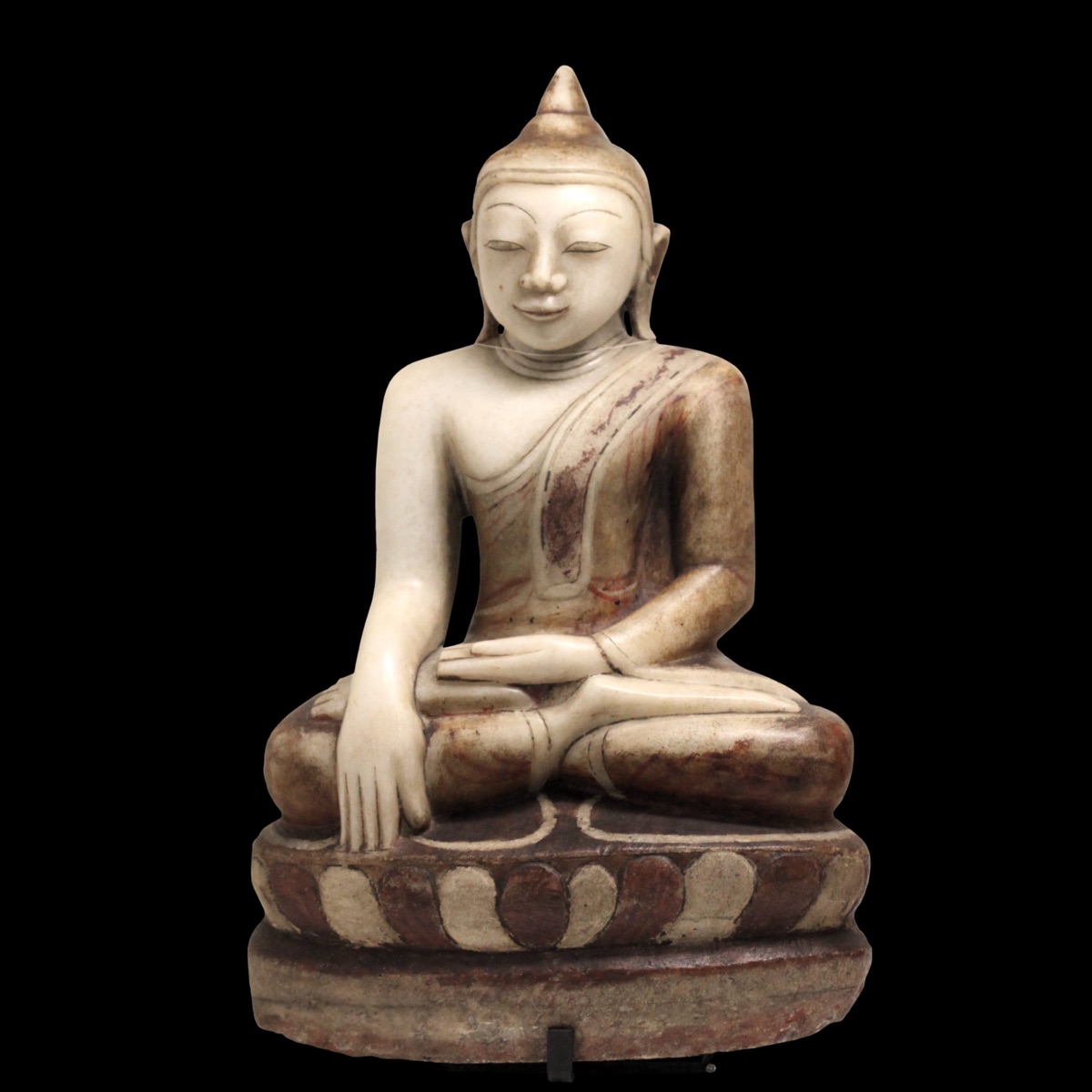 A white marble Burmese Buddha seated cross-legged, the right hand reaching down over the knee to touch the base, the left in his lap