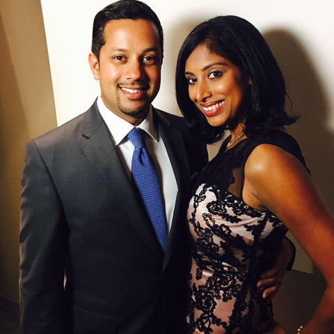Smiling couple posing together, a man in a suit and a woman in a lace dress